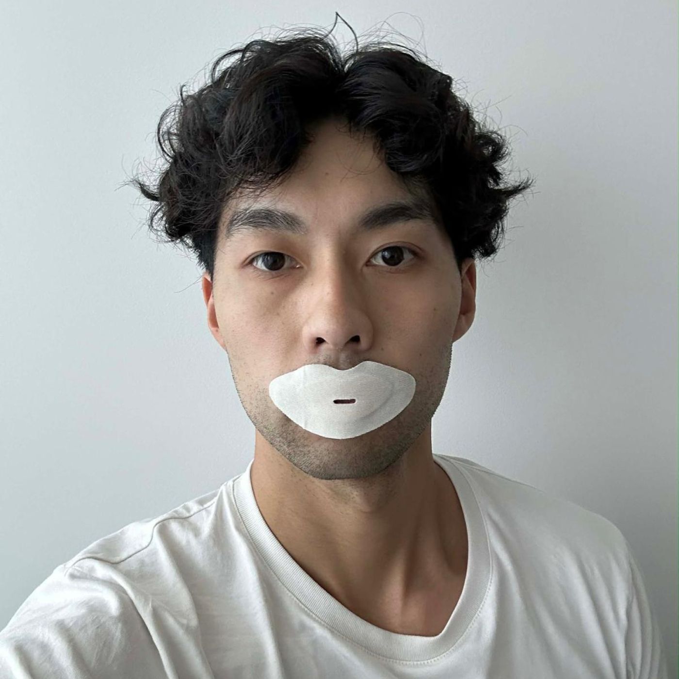 Man wearing a Sayang Sleep Strip in a selfie, highlighting the morning ritual of placing the strip in the Sayang Journey booklet and waking into calm.