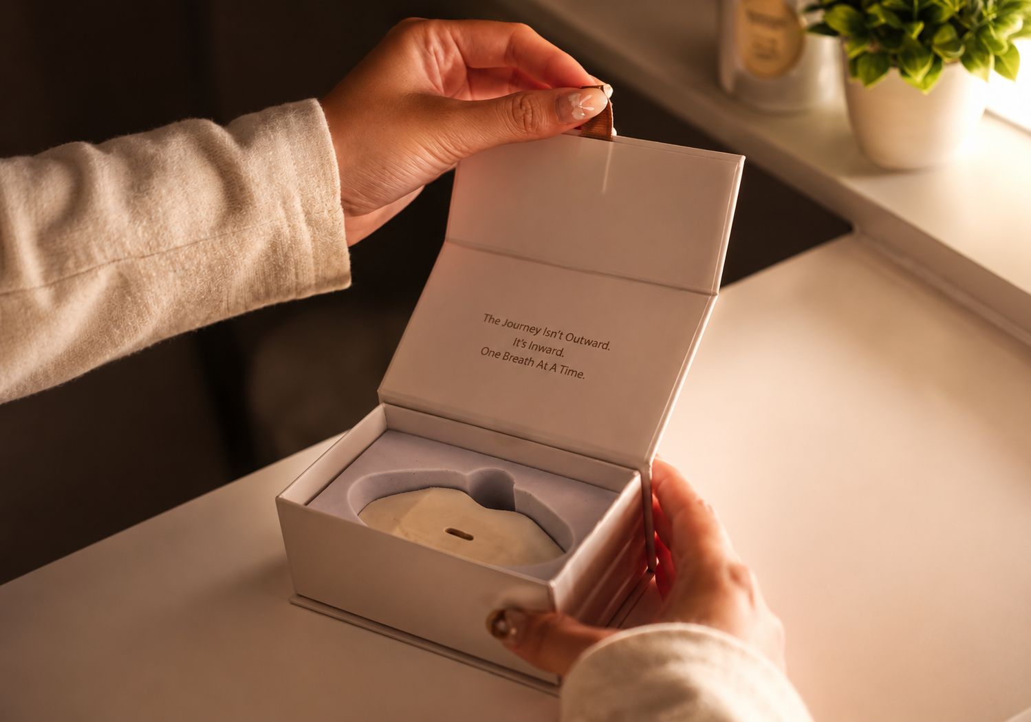Hands opening the Sayang Sleep Strips premium magnetic box with a sleep strip stored in the fitted inner tray.
